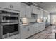 Modern white kitchen with stainless steel appliances, white countertops, and stylish backsplash at 12709 Messenger Row, Huntersville, NC 28078