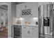 A kitchen wet bar features white cabinets, a wine rack, a wine cooler, and a stainless steel refrigerator at 12709 Messenger Row, Huntersville, NC 28078