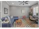 Cozy living room features a blue sofa, colorful rug, and a ceiling fan for added comfort at 12709 Messenger Row, Huntersville, NC 28078