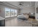 Spacious main bedroom featuring tray ceiling, large windows, neutral decor, and wood-look flooring at 12709 Messenger Row, Huntersville, NC 28078