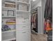 Spacious walk-in closet with custom shelving, drawers, and hanging rods for optimal organization at 12709 Messenger Row, Huntersville, NC 28078