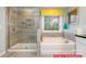 Bright bathroom featuring tiled walk-in shower, soaking tub and window for natural light at 130 Fordingbridge Ln, Mooresville, NC 28115