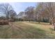 Large backyard featuring a storage shed surrounded by mature trees and lush greenery at 1315 Vickie Ln, Matthews, NC 28104