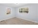 Bright bedroom featuring wood floors, two windows offering outdoor views, and soft natural light at 1315 Vickie Ln, Matthews, NC 28104