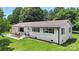 Well-manicured lawn surrounds this freshly renovated white brick home with new shutters, lighting, and garage at 1315 Vickie Ln, Matthews, NC 28104
