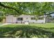 Charming home with green lawn, brick facade, matching shutters, and a lovely shade tree in a desirable neighborhood at 1315 Vickie Ln, Matthews, NC 28104