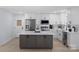 Modern kitchen features white cabinets, stainless steel appliances, and a gray center island with a white countertop at 1315 Vickie Ln, Matthews, NC 28104