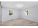 Bright, empty bedroom with wood floors, two windows, and a modern ceiling light fixture at 1315 Vickie Ln, Matthews, NC 28104