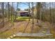 Scenic backyard featuring a multi-level deck, stone stairway, and lush landscaping at 135 Frostcliff Ln, Mooresville, NC 28117