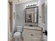 Bathroom with a framed mirror and vanity with granite counters, in a renovated home at 135 Frostcliff Ln, Mooresville, NC 28117