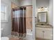 Cozy bathroom featuring a tiled shower and granite vanity with a decorative framed mirror at 135 Frostcliff Ln, Mooresville, NC 28117