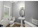 Half bathroom features a pedestal sink, a toilet, and a window at 135 Frostcliff Ln, Mooresville, NC 28117