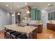 This open kitchen offers granite counters, wood floors, and a stone range hood at 135 Frostcliff Ln, Mooresville, NC 28117