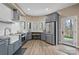 Bright kitchen featuring gray cabinets, modern appliances, and natural light from large windows at 135 Frostcliff Ln, Mooresville, NC 28117