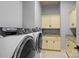 Laundry room featuring modern washer and dryer, cabinetry, sink, and granite counters at 135 Frostcliff Ln, Mooresville, NC 28117