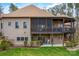 Rear exterior with a covered porch, screened porch, lower level patio, and stone retaining wall at 135 Frostcliff Ln, Mooresville, NC 28117