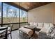 Covered and screened in porch with a fan, wood ceiling and comfortable seating with a fire pit table at 135 Frostcliff Ln, Mooresville, NC 28117