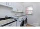 Functional laundry room with sink, cabinets, and modern washer/dryer at 15327 Rush Lake Ln, Huntersville, NC 28078