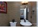 Stylish powder room with textured wallpaper, a decorative mirror, and updated fixtures at 15327 Rush Lake Ln, Huntersville, NC 28078