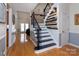 Inviting staircase with wood treads, iron railings, and decorative wall accents in a bright, open space at 15327 Rush Lake Ln, Huntersville, NC 28078