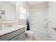 Bright bathroom with a shower-tub combo, gray vanity, and large mirror at 19412 Bird Meadow Dr, Huntersville, NC 28078