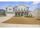 Inviting two-story home features a covered front porch, attached garage, and well-maintained lawn at 19412 Bird Meadow Dr, Huntersville, NC 28078
