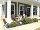 Cozy front porch with chairs, potted plants, and a welcome sign offers a relaxing outdoor space at 19412 Bird Meadow Dr, Huntersville, NC 28078