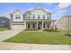 Inviting two-story home with a manicured lawn, covered porch, and attached two-car garage at 19412 Bird Meadow Dr, Huntersville, NC 28078