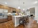 Eat-in kitchen features a kitchen island with seating and stainless steel appliances next to an open living space at 2018 Puddle Pond Rd, Indian Trail, NC 28079
