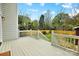 A view of the outdoor back deck with white railings overlooking the green backyard with mature trees at 2208 Bay St, Charlotte, NC 28205