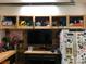 A garage with storage shelves, a TV, a workbench, and a refrigerator covered with stickers at 2916 Grand Union Way, Charlotte, NC 28209