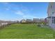 Expansive backyard with lush green grass, black fencing, and view of neighborhood homes at 3013 Whipcord Dr, Waxhaw, NC 28173