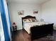 Bright bedroom boasts hardwood floors, queen bed, and a sunlit window with charming blue curtains at 3013 Whipcord Dr, Waxhaw, NC 28173