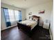Cozy bedroom featuring hardwood floors, a queen-sized sleigh bed, and bright natural light at 3013 Whipcord Dr, Waxhaw, NC 28173