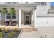Inviting front porch with brick accents, seating, and decorative plants, leading to the front door and garage at 3013 Whipcord Dr, Waxhaw, NC 28173