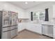 Well-lit kitchen featuring stainless steel appliances, white cabinets, and a window above the sink, ideal for cooking at 3013 Whipcord Dr, Waxhaw, NC 28173