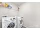 Bright laundry room features a modern white washer and dryer, with shelf storage above at 3013 Whipcord Dr, Waxhaw, NC 28173