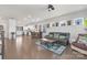 Bright living room featuring hardwood floors, modern furniture, and a view of the kitchen area at 3013 Whipcord Dr, Waxhaw, NC 28173
