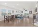 Open living room with hardwood floors, large windows, and dining area perfect for entertaining and relaxation at 3013 Whipcord Dr, Waxhaw, NC 28173