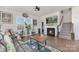 Bright living room with a fireplace, hardwood floors, and ample seating, complemented by decor and natural light at 3013 Whipcord Dr, Waxhaw, NC 28173
