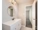Updated bathroom with white vanity and a round mirror at 3023 Fairglen Rd, Charlotte, NC 28269