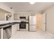 Cozy kitchen featuring stainless steel appliances, white cabinets, and laminate flooring at 3023 Fairglen Rd, Charlotte, NC 28269