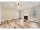 Spacious living room boasts a fireplace, ceiling fan, and wood-look flooring at 3023 Fairglen Rd, Charlotte, NC 28269