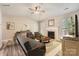 Bright living room with fireplace, neutral walls, ceiling fan, and wood-look flooring at 3023 Fairglen Rd, Charlotte, NC 28269