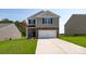 Two-story home featuring stone accents, gray siding, a two-car garage, and a well-manicured lawn at 3052 Ora Smith Rd, Lincolnton, NC 28092