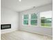 Living room featuring an electric fireplace, luxury vinyl plank flooring, and three large windows at 3052 Ora Smith Rd, Lincolnton, NC 28092