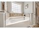 Bathroom featuring a large soaking tub with tile surround and natural light at 324 Kerrydale Ct # 106, Clover, SC 29710