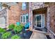 Inviting front porch with brick facade and blue chairs, enhanced by lush landscaping at 324 Kerrydale Ct # 106, Clover, SC 29710