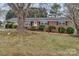 Charming red brick home featuring a well-maintained lawn, a porch swing and mature shade tree at 3509 Havenwood Rd, Dallas, NC 28034