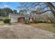 Red brick home with a covered carport and a lush front yard with mature trees at 3509 Havenwood Rd, Dallas, NC 28034